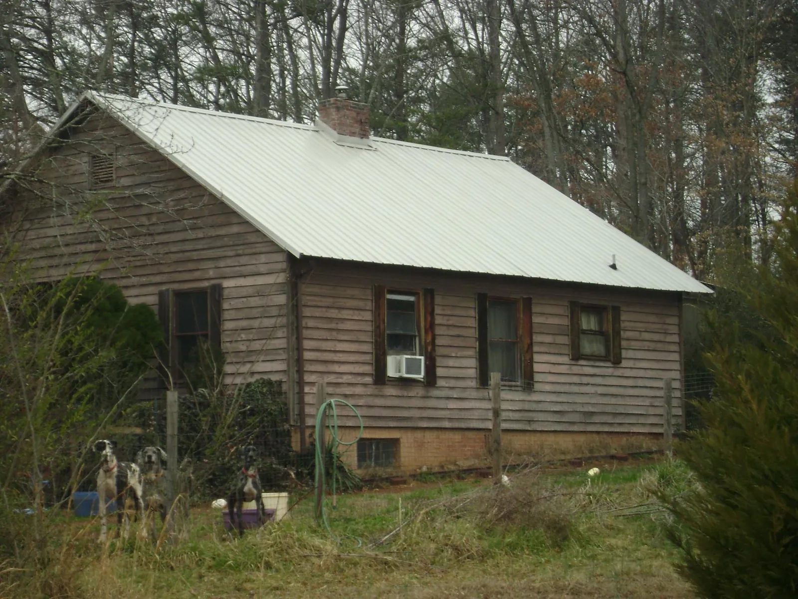 White metal roof on an old wood sided farmhouse, from a Metal Roof Installation job in Neosho